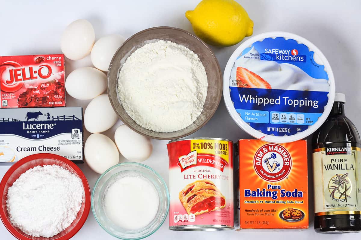 Ingredients for cherry jello cake recipe laying on a flat white surface