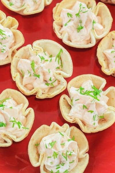 smoked salmon appetizer cream cheese tortillas cups on a red plate