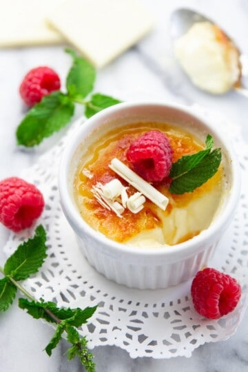 white chocolate creme brulee with raspberries and mind on top