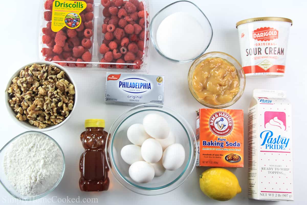 Ingredients for the raspberry cake laying on a flat white surface and photographed from overhead