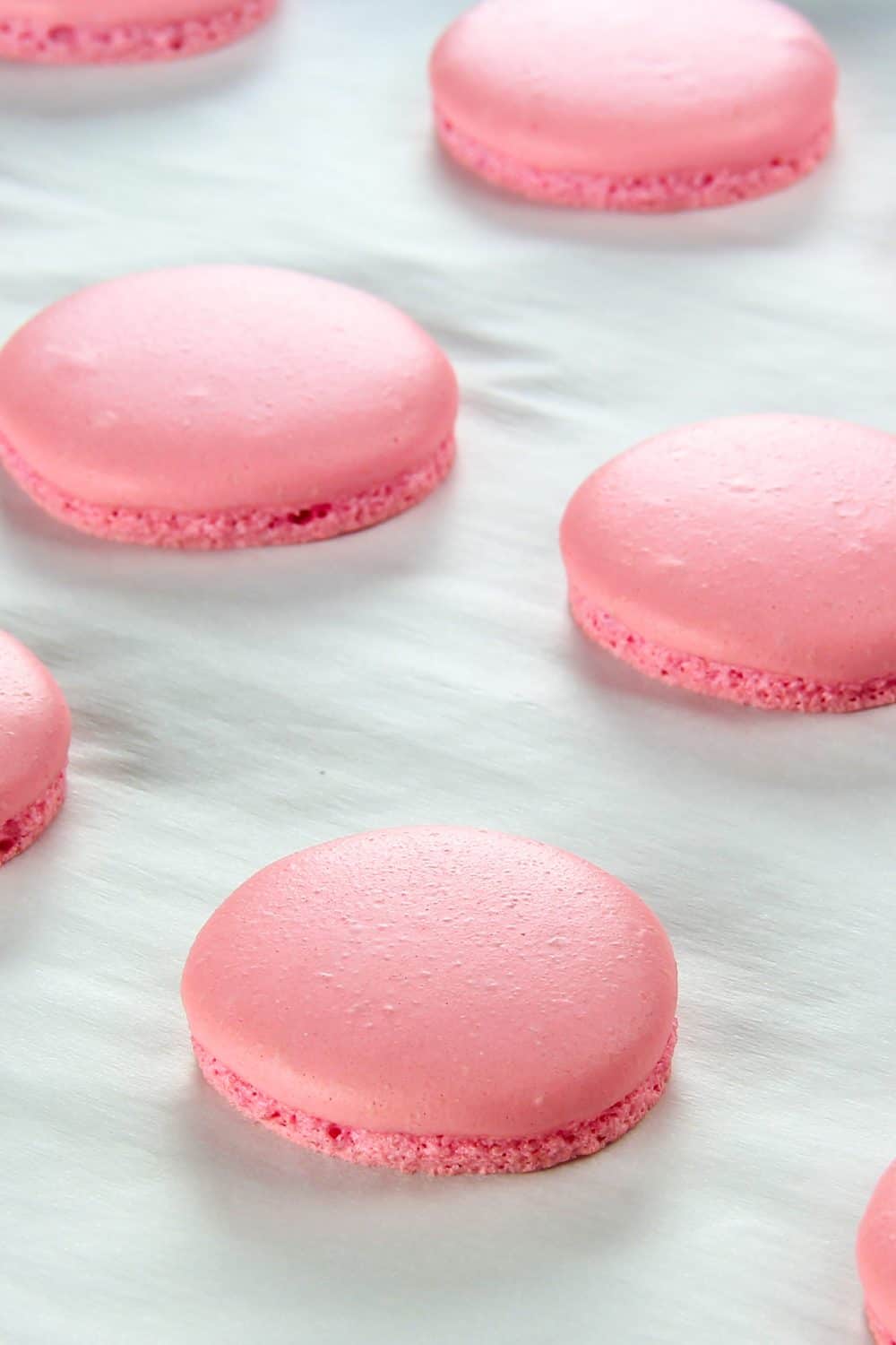 pink macarons baked on parchment paper