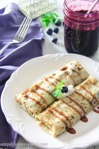 Blueberry crepes with blueberry sauce and a mason jar with blueberry pie filling