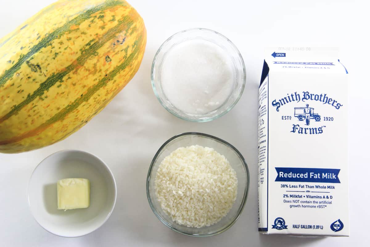 an overhead image of ingredients for rice pudding on a white background