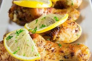 baked chicken drumsticks with sliced lemons on top