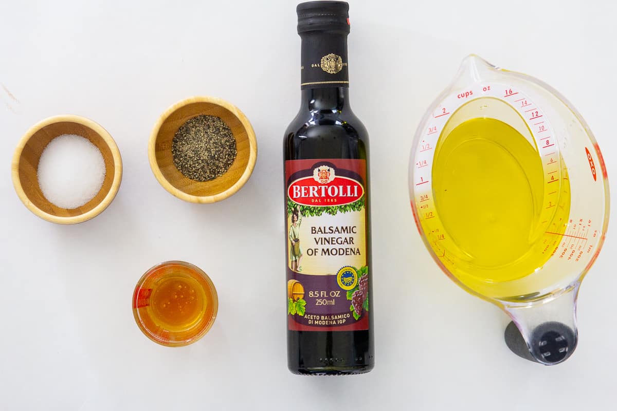 Ingredientes del aliño de la ensalada casera - miel, sal, pimienta, vinagre balsámico, aceite de oliva