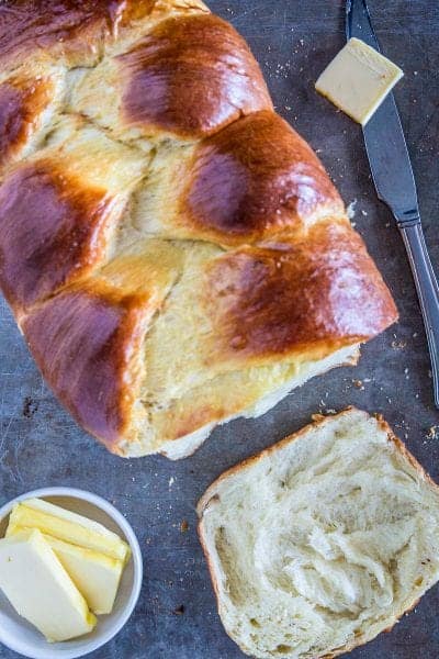 brioche bread loaf with a slice of brioche bread and sliced butter beside it