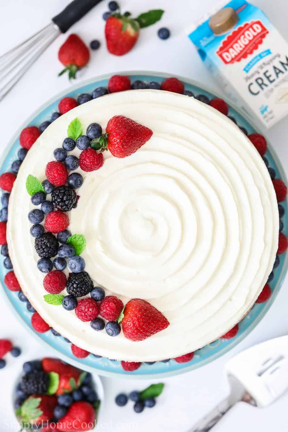 overhead shot of a white Chantilly cake with berries on top