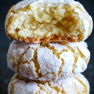 chewy almond cookies with powdered suagr stacked on top of each other.