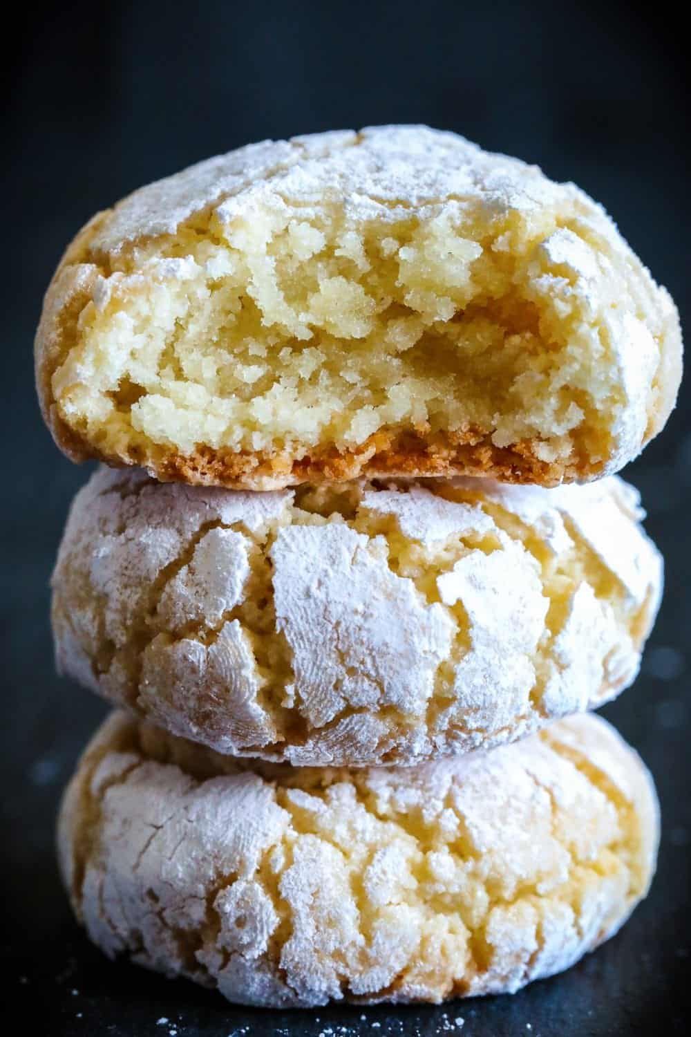 chewy almond cookies with powdered suagr stacked on top of each other.