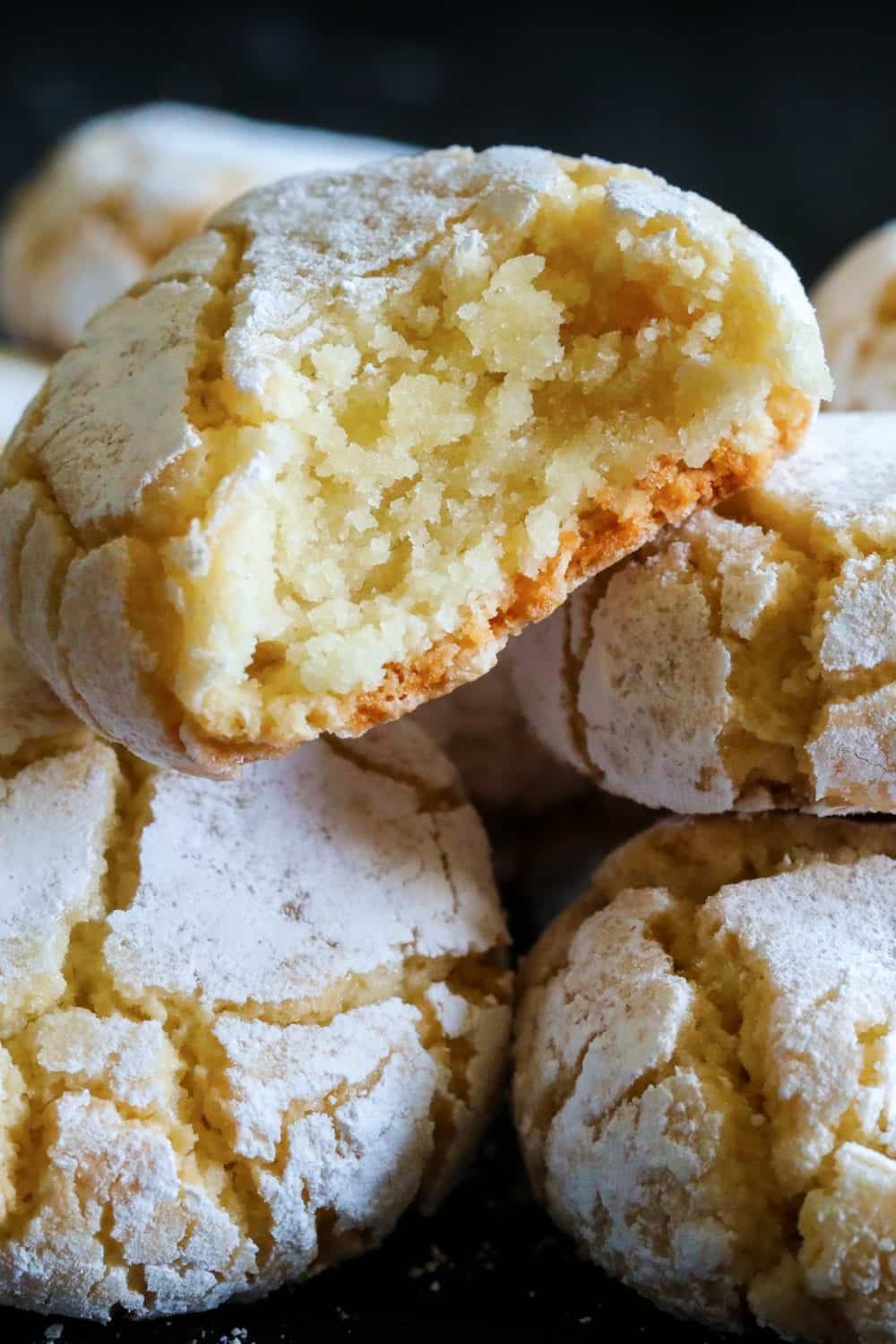 chewy almond cookies with powdered suagr stacked on top of each other.