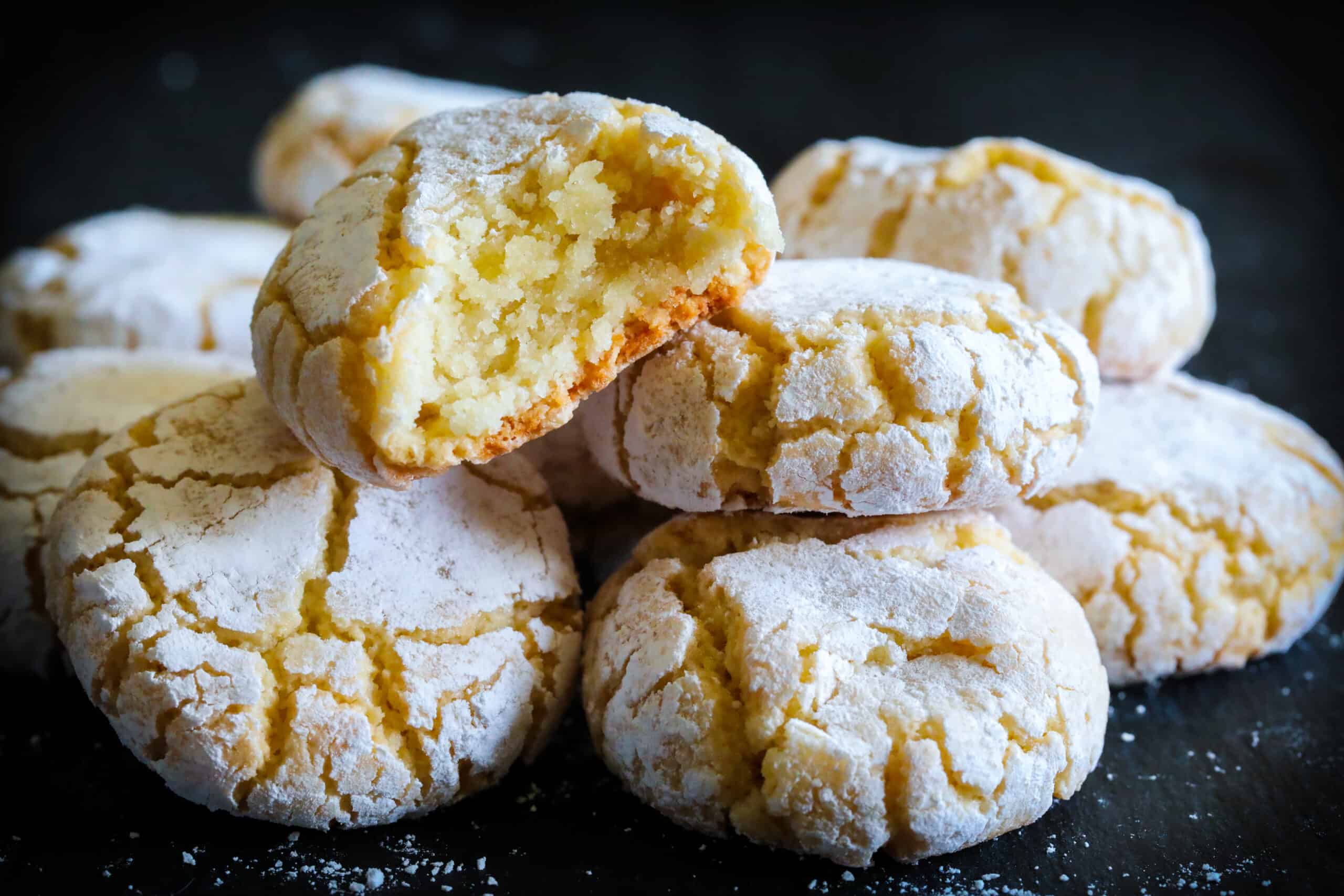 close up image of a stack of amaretti cookies with one bitten