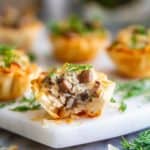 phyllo shells stuffed with chicken mushrooms and cheese and fresh dill on top