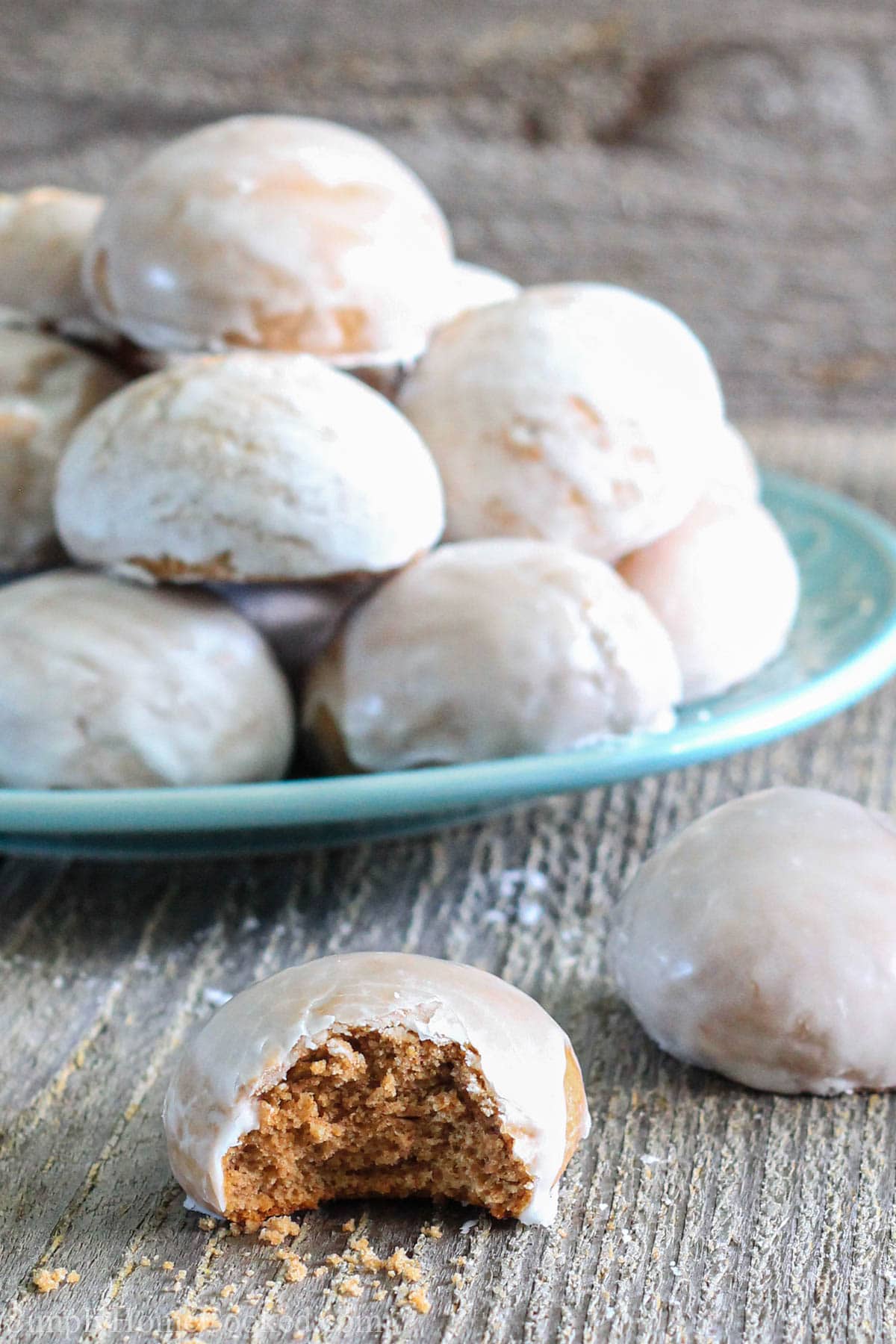 Vertical image of Russian Pryaniki with Mint Glaze piled on a plate with one missing a bite