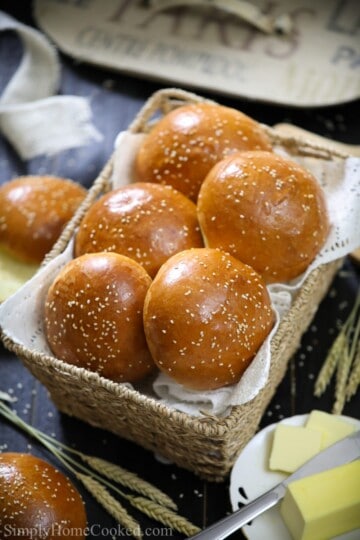 brioche buns in a basket with sliced butter beside it