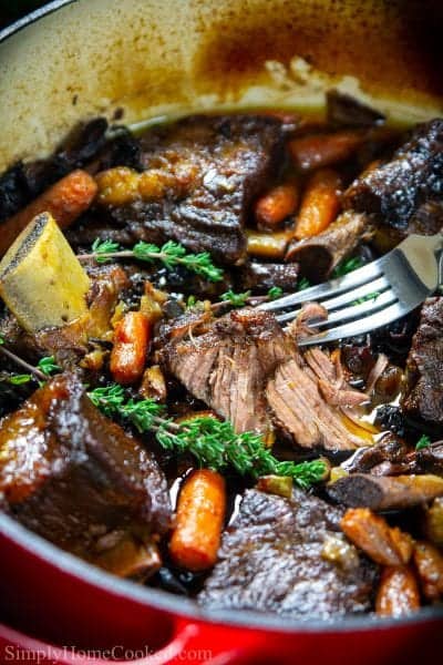 braised beef short ribs in a red dutch oven pot