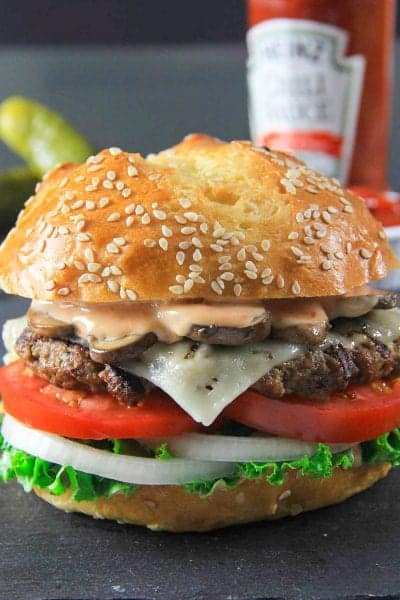 Beef burger with mushrooms, fry sauce, lettuce, tomatoes, onions, and brioche bun.