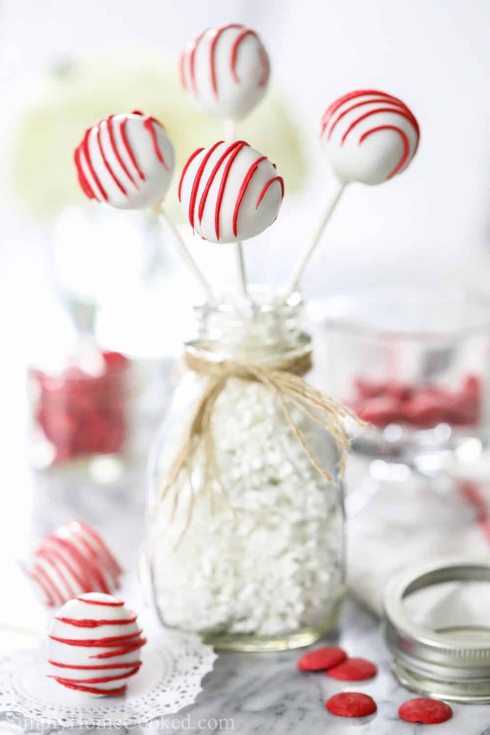 red velvet cake pops in a glass bottle with burlap string around it.