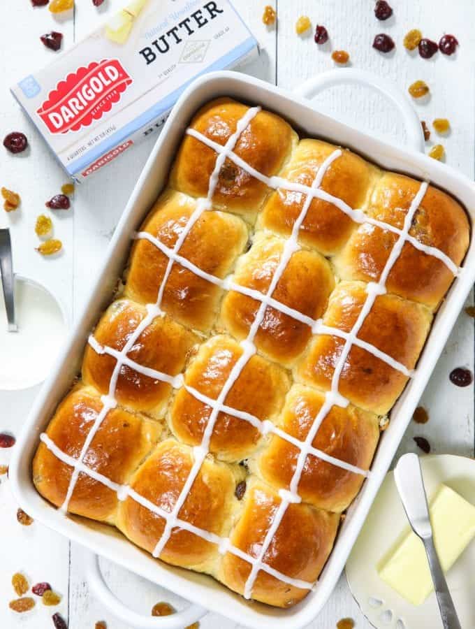 Warm fluffy and butter brioche hot cross buns in a white baking dish ready to eat