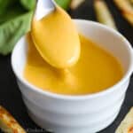 close up image of homemade chick-fil-a sauce in a white bowl with a spoon in it