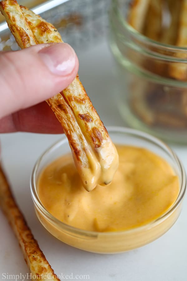 French fries dipped in 3 ingredient Chick-fil-a sauce with fries in the background.