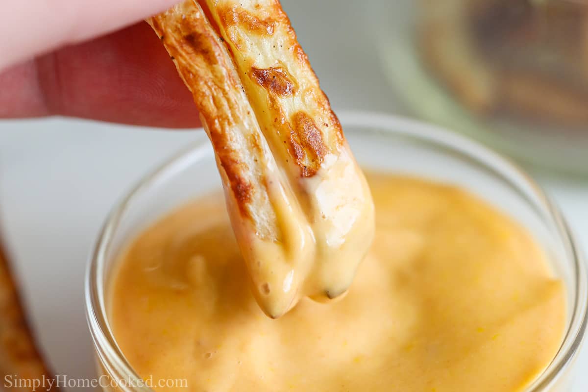 Air fryer french fries dipped in dipping sauce.