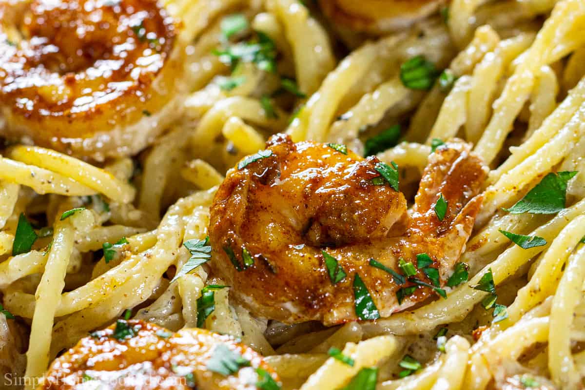 Close up of cajun shrimp in pasta with a cream sauce.