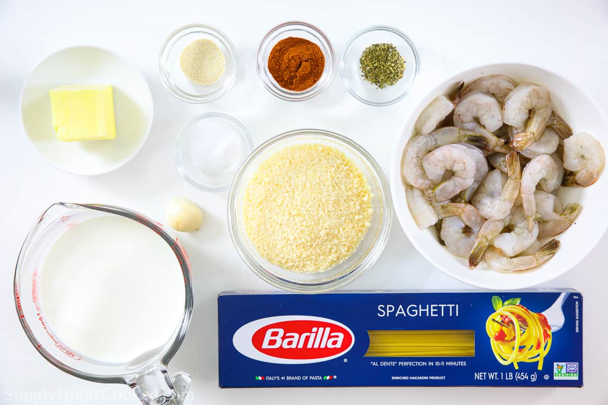 Ingredients for Cajun Shrimp Pasta, including pasta, shrimp, heavy cream, butter, parmesan cheese, salt, pepper, cayenne, oregano, onion powder, and paprika.