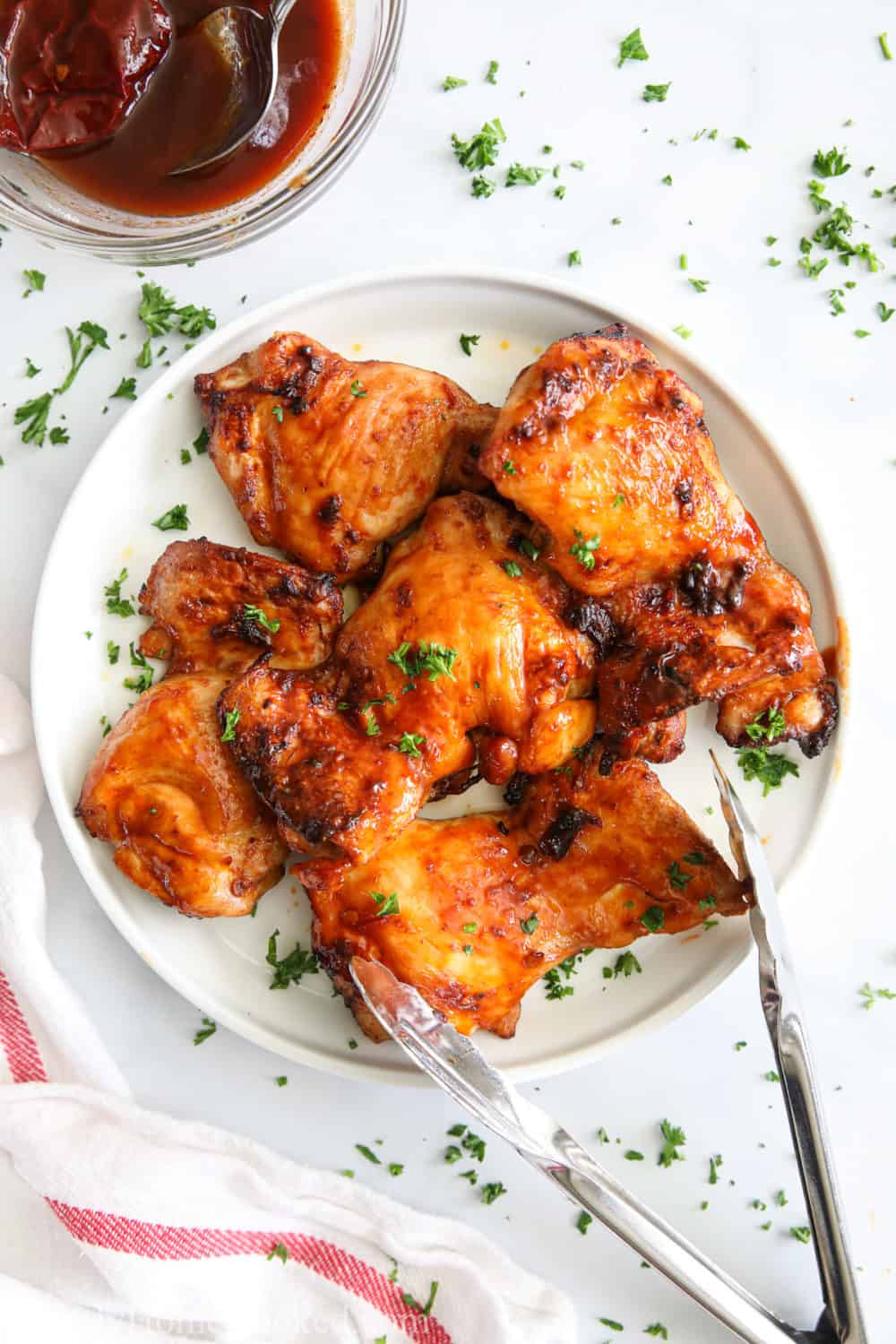 Plate of Air Fryer Chipotle Chicken Thighs and sauce in the background.