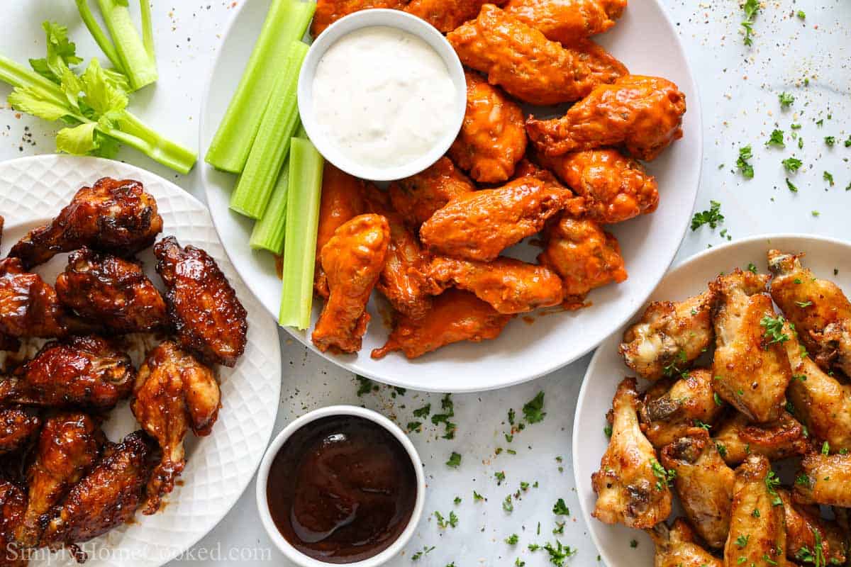 overhead image of bbq wings, buffalo wings, and lemon pepper wings on white plates