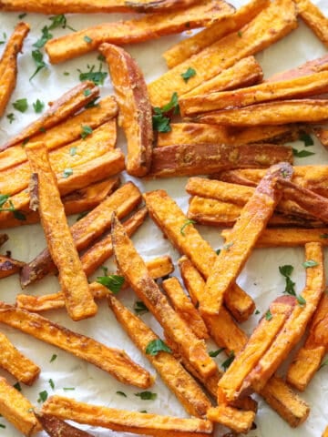 Close up of the Best Air Fryer Sweet Potato Fries with a sprinkling of parsley.
