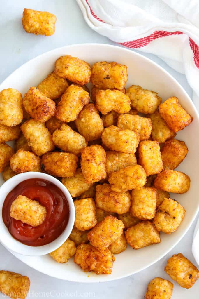 Plate of Crunchy Air Fryer Tater Tots with one in a dish of ketchup.