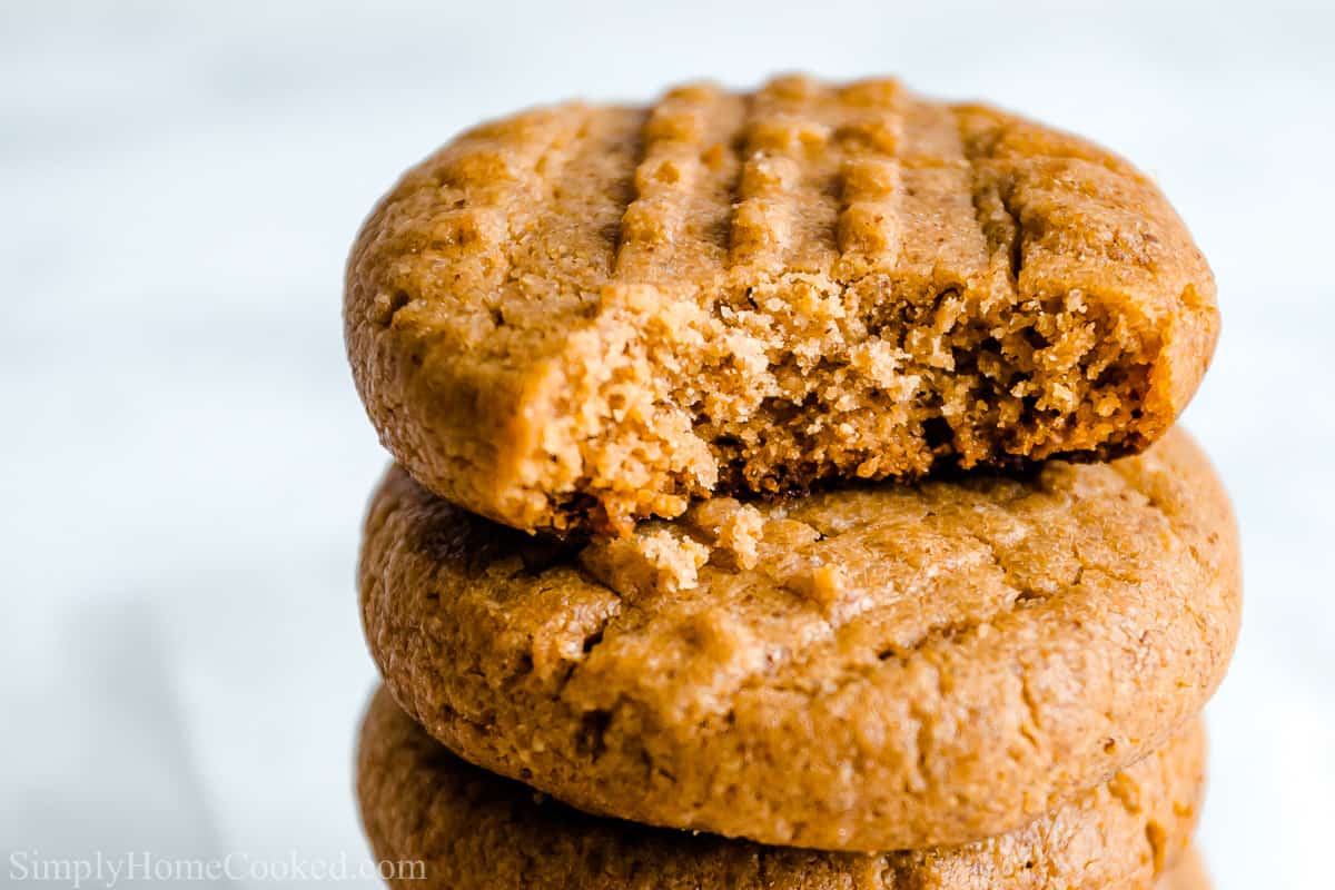 Close up of stack of Easy Keto Peanut Butter Cookies, the top one missing a bite.