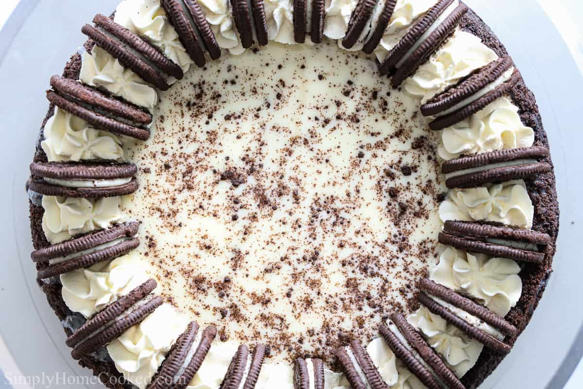 Aerial view of an Easy Oreo Cheesecake, decorated with whipped cream, Oreos, and cookie crumbs.