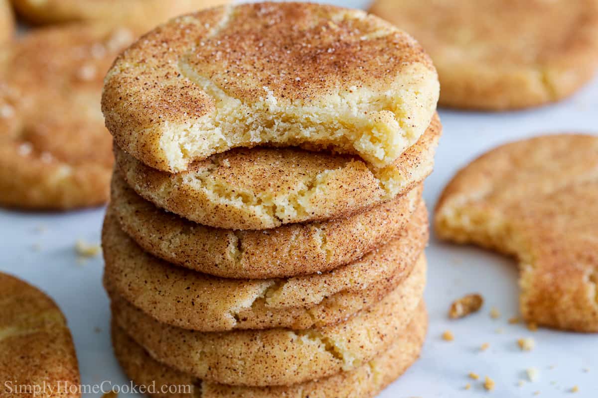 Stack of Soft Snickerdoodle Cookies with more in the background, the top one in bitten.
