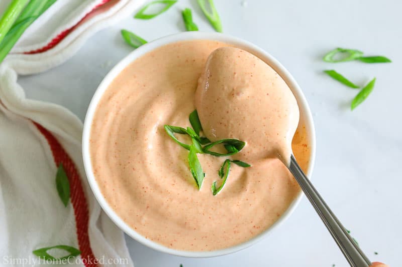 overhead photo of yum yum sauce in a white bowl with a spoon inside