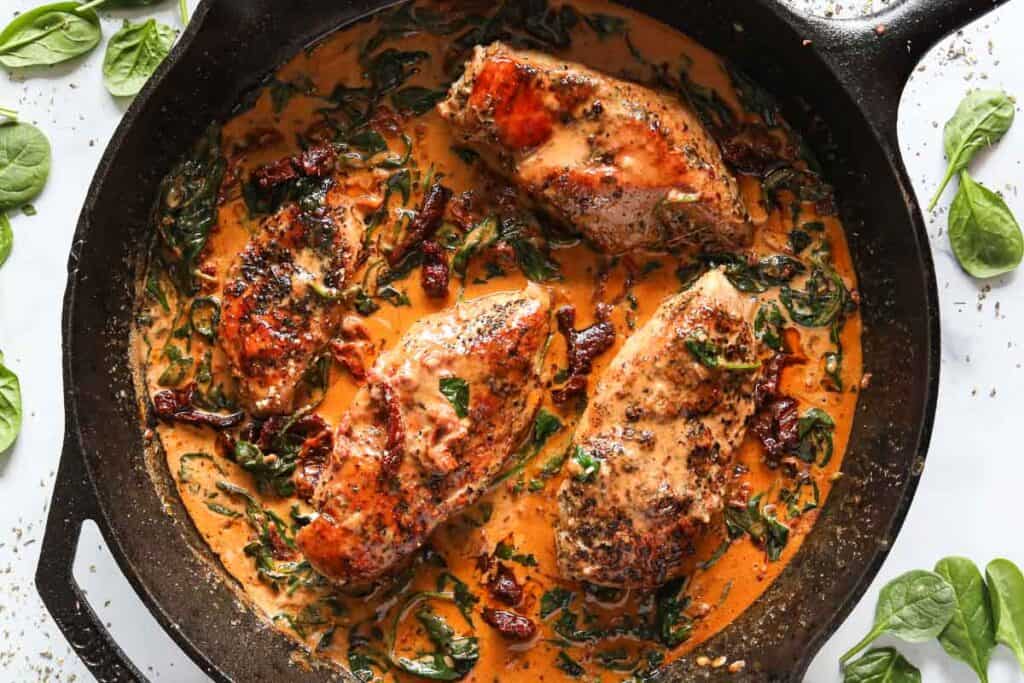 Overhead image of Creamy Tuscan Chicken in a cast iron skillet.