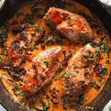 Overhead image of Creamy Tuscan Chicken in a cast iron skillet.