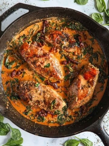 Overhead image of Creamy Tuscan Chicken in a cast iron skillet.