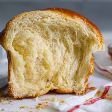 Buttery Brioche Bread with honey and butter in the background.