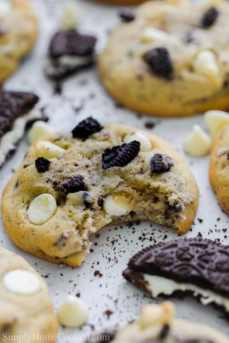 Close up of Cookies and Cream Cookies, one with a bite missing, and some Oreo cookie pieces nearby.