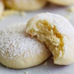Easy Cream Cheese Cookies dusted with powdered sugar and one missing a bite