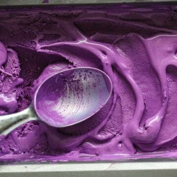 Easy Ube Ice Cream in a pan with a spoon.