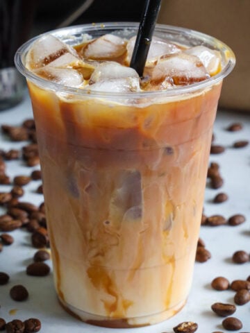 Cup of Iced Caramel Macchiato with a straw.