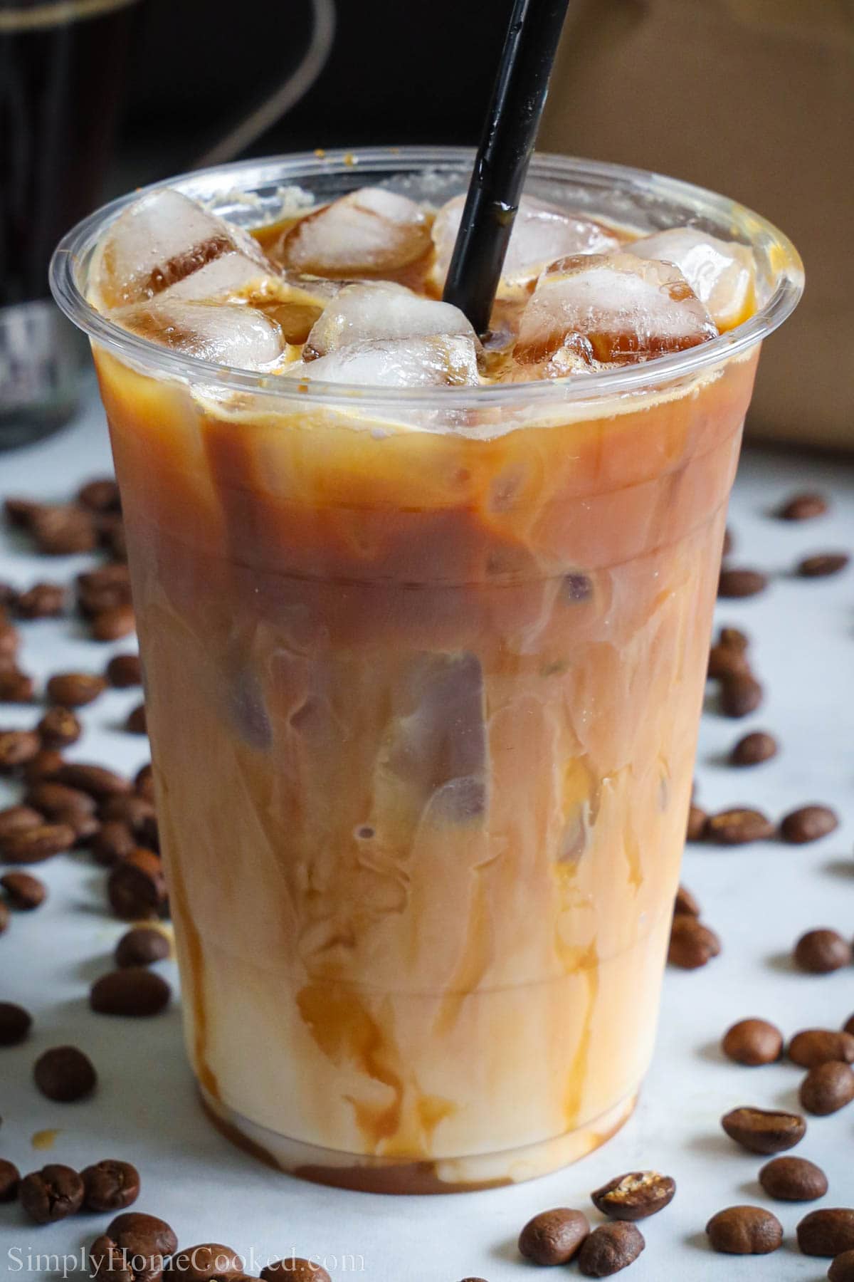Cup of Iced Caramel Macchiato with a straw. 