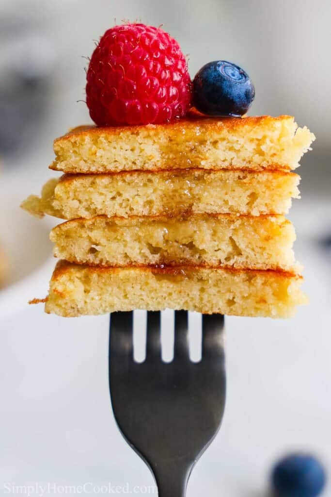 Forkful of Almond Flour Pancakes with a raspberry and blueberry on top.