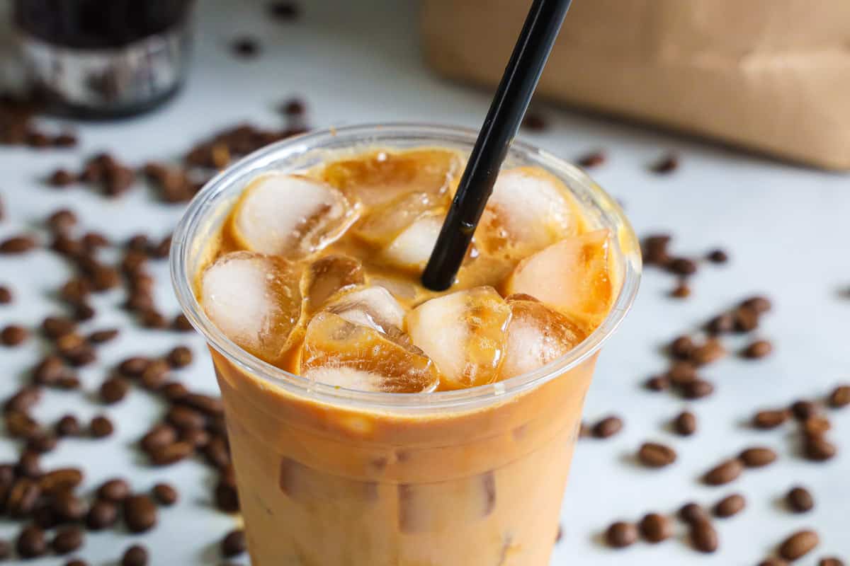 Horizontal image of iced caramel macchiato with ice at the top of the cup