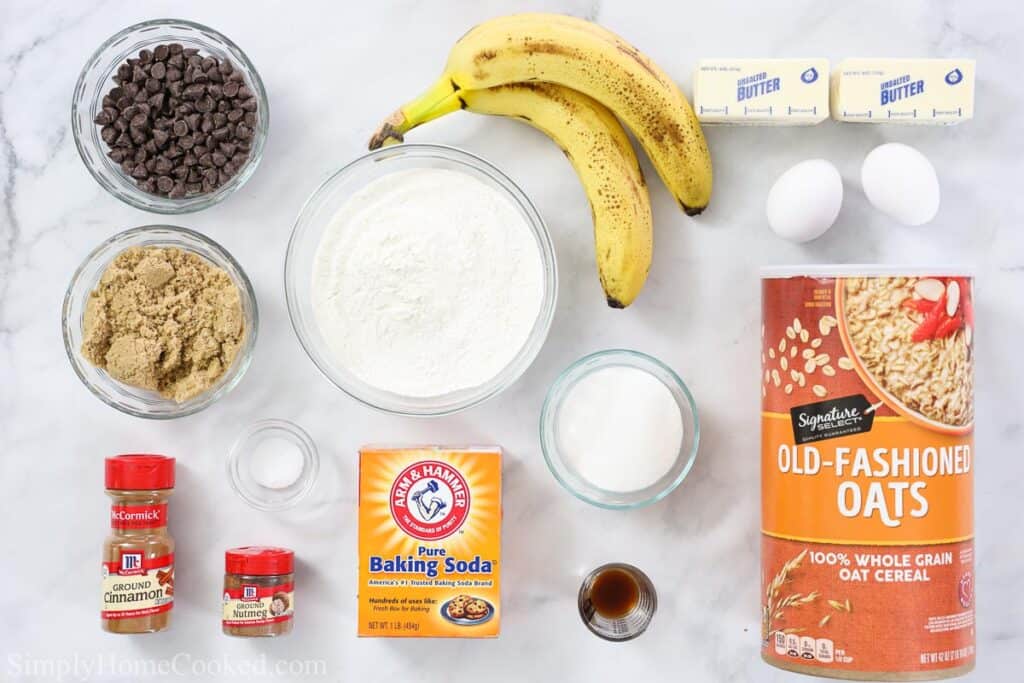 These Chewy Banana Oatmeal Cookies are so moist and chewy. You'll love the flavor and texture of this delicious dessert. #cookierecipe #dessertideas #makeaheadcookierecipe #makeaheadoatmealcookies overhead image of ingredients for banana oatmeal cookies on a white marble background