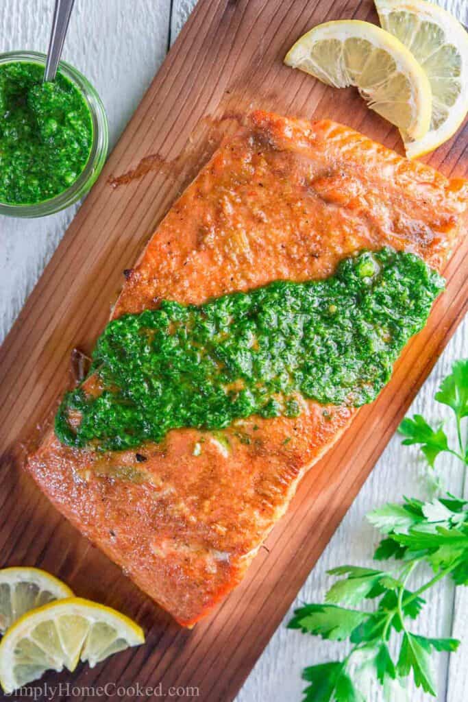 Vertical image of Cedar Plank Salmon with chimichurri sauce on top