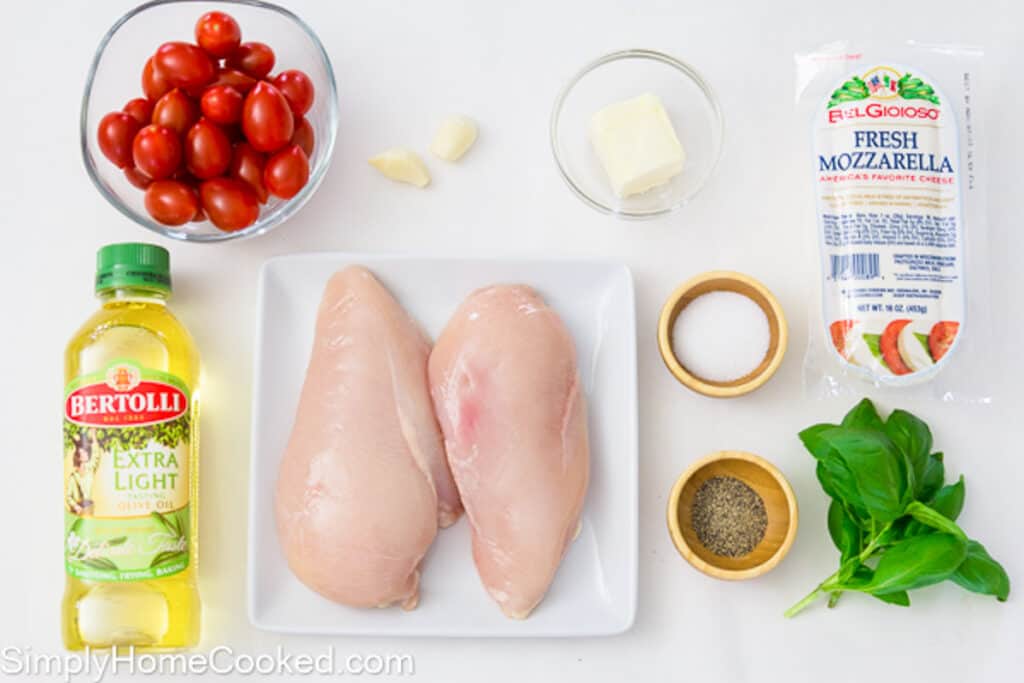 Ingredients for Chicken Caprese, including chicken breasts, olive oil, fresh mozzarella, cherry tomatoes, garlic, basil, salt, pepper, and butter.