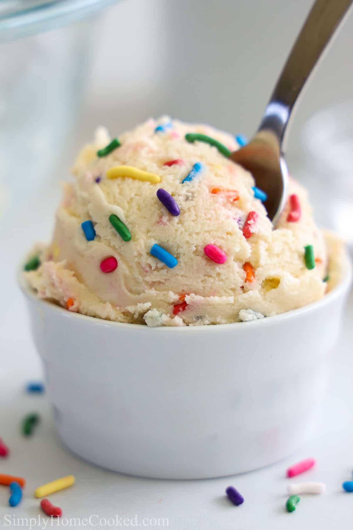 Vertical image of Edible Sugar Cookie Dough with rainbow sprinkles in a white cup
